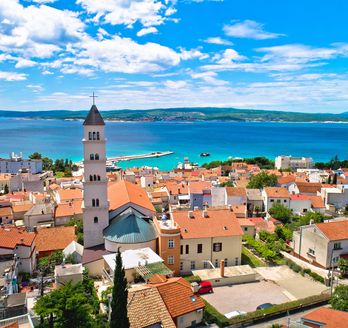 Eine Küstenstadt mit roten Dächern und Blick auf das Meer.