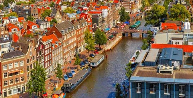 Blick von der Westerkerk die Prinsengracht hinauf; vorne rechts im Bild der Museumstrakt des Anne Frank Hauses, dessen rotes Ziegeldach gleich dahinter zu erkennen ist. 