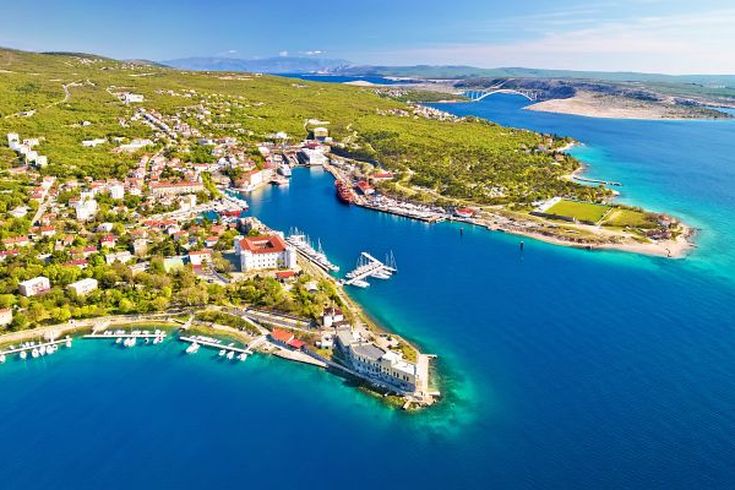 Eine Luftaufnahme einer Küstenstadt mit einem Hafen.