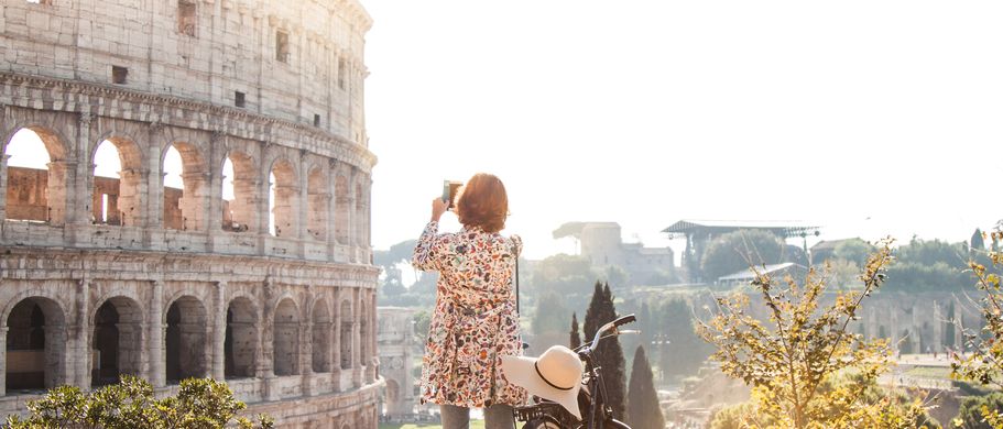 Das majestätische Kolosseum in Rom, Italien, ein antikes römisches Amphitheater, das unter einem dramatischen Sonnenuntergangshimmel beleuchtet wird.