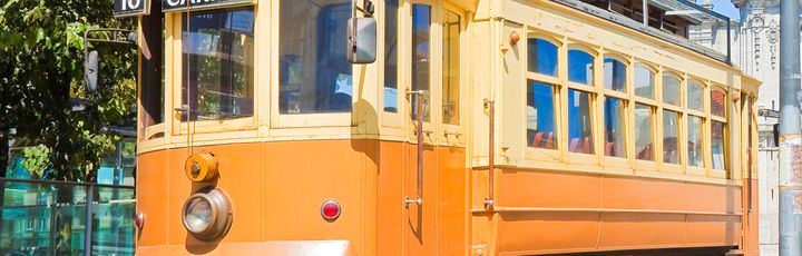 Eine gelbe Straßenbahn in einer Stadt.