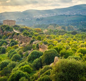 Eine Landschaft mit Ruinen auf einem Hügel.