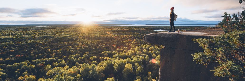 Eine Person steht auf einem Felsen am Cup Saucer Trail auf Manitoulin Island, einer Insel im Huronsee in Ontario.