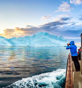 Mensch auf Schiff beobachtet Eisberge in Finnland