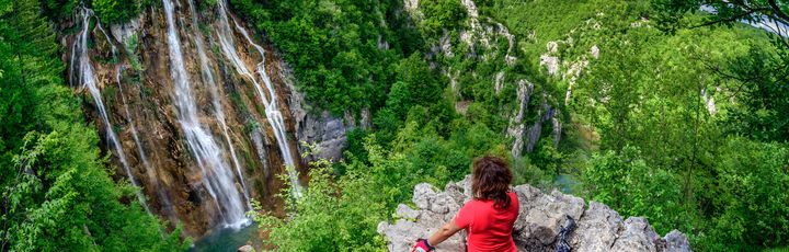 Radfahrerin schaut auf den Wasserfall plitvicer Seen