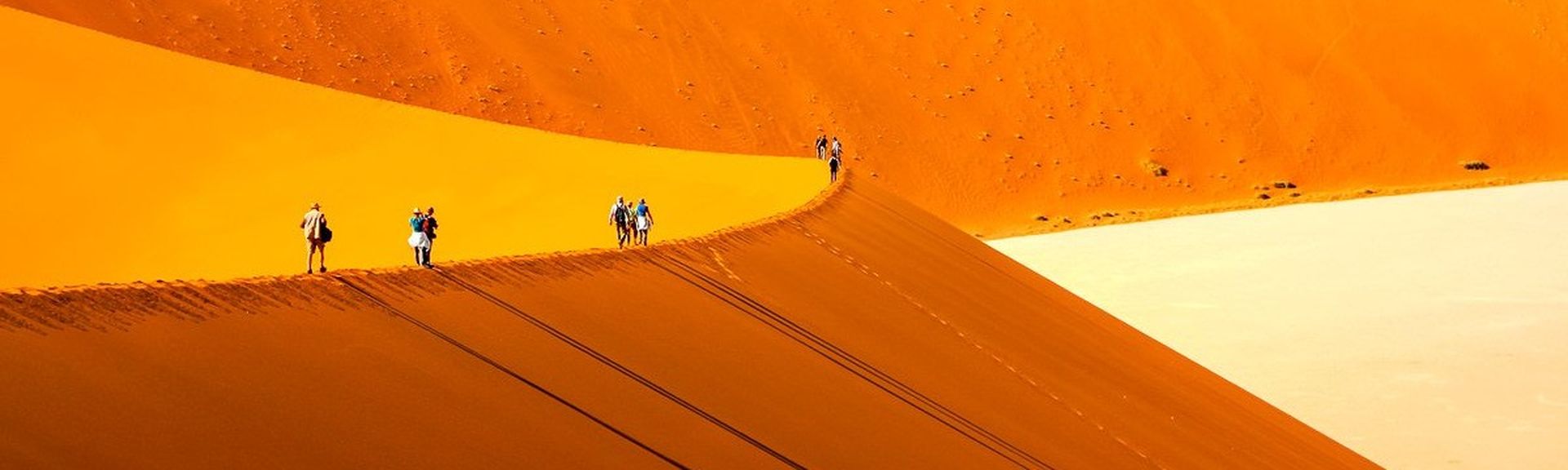 Menschen gehen auf Düne in Afrika