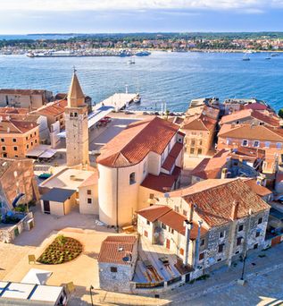 Eine Luftaufnahme der historischen Stadt Umag, Kroatien, mit roten Dächern und Blick auf das Meer.