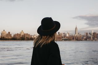 Frau mit Hut blickt auf Brooklyn in New York