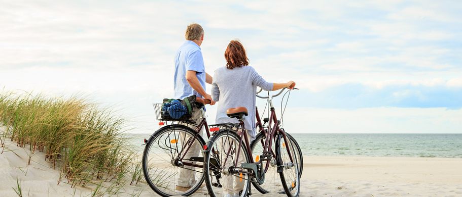 Paar mit Fahrrad am Strand
