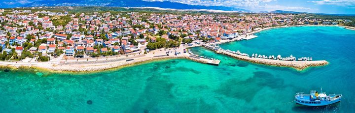 Eine Panoramaansicht von Novalja, Kroatien, mit der Stadt und dem Meer.