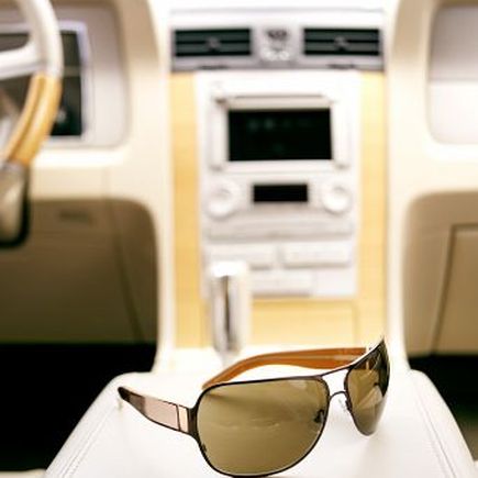 Eine Person trägt eine schwarze Sonnenbrille mit einem markanten goldenen Rocawear-Logo an der Seite, die das Gesicht bedeckt.