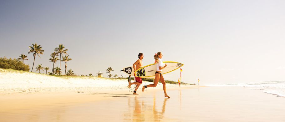 Camper Australien Urlaub Reisen Surfer rennen am Strand ins Meer