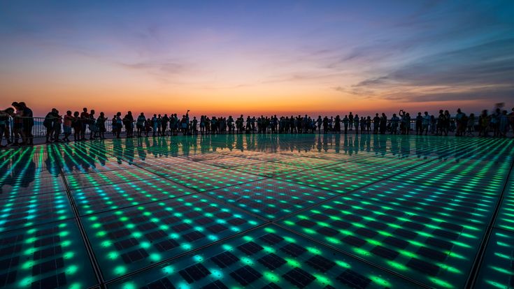 Glasplatten bei Dunkelheit, im Hintergrund die Silhouette der Menschen.