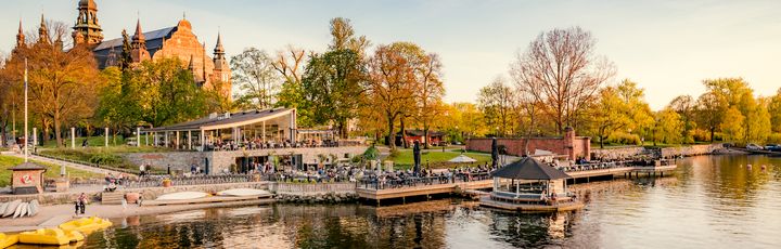 Eine Stadtansicht mit Gebäuden und einem Fluss, umgeben von Herbstbäumen.
