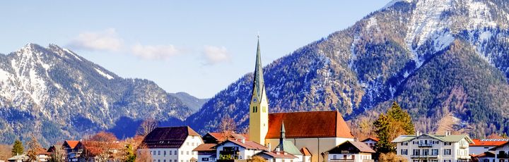Eine Stadt am Ufer eines Sees, umgeben von schneebedeckten Bergen, Bayern. Tegernsee.