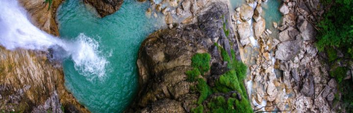 Eine Landschaft mit einem Wasserfall und einem Fluss.