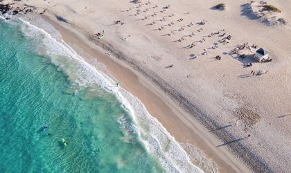 Eine Luftaufnahme eines Strandes mit türkisfarbenem Wasser.