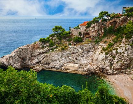 Eine Bucht mit türkisfarbenem Wasser und einem felsigen Strand.