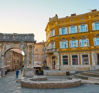 Ein Stadtplatz in Pula, Kroatien, mit historischen Gebäuden.
