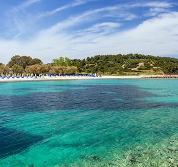 Blick vom Meer auf Kallithea mit seine kleinen Häusern und dem Strand.