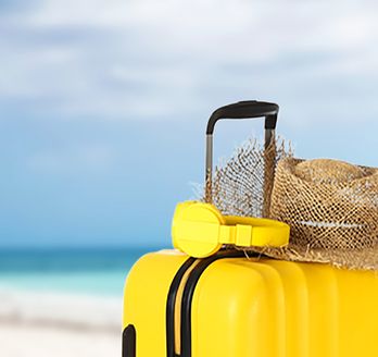 Gelber Koffer am Strand.