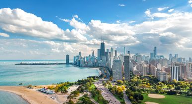 Luftaufnahme der Skyline von Chicago aus der Vogelperspektive, Blick auf den Michigansee und die Wolkenkratzer der Innenstadt von Chicago aus dem Lincoln Park, Illinois, USA. Das alles bei strahlend blauem Himmel.