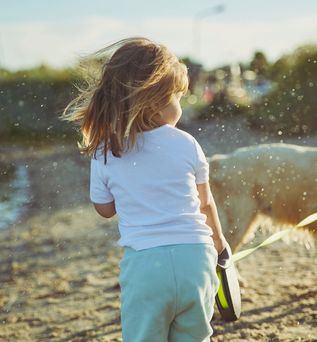 Kind mit Hund am Strand