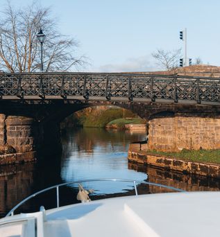 Hausbbot fährt unter einer Brücke durch