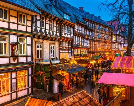 Die historische Stadt Goslar in Deutschland mit ihren Fachwerkhäusern und einer beleuchteten Weihnachtsmarktatmosphäre.