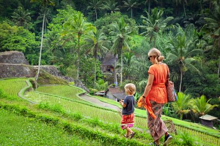 Frau geht mit Kind durch die Salzterrassen auf Bali