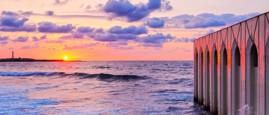 Sonnenuntergang über dem Atlantik und Mauer