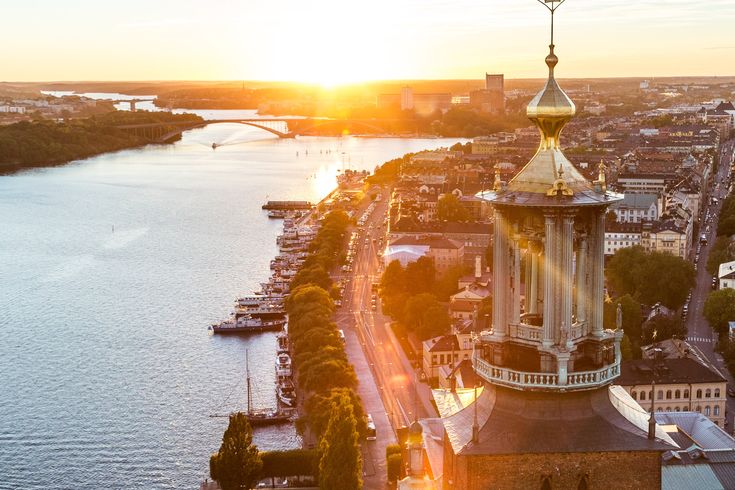 Die Skyline von Stockholm bei Sonnenuntergang, mit einem See und Gebäuden.