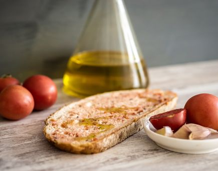 Brotschiebe mit Olivenöl und Tomaten daneben