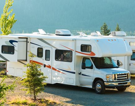 Ein Wohnmobil parkt in einer grünen Landschaft.