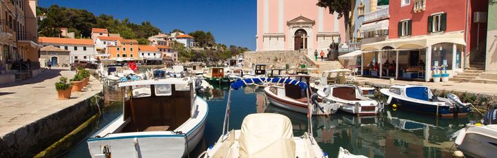 Eine Hafenstadt mit bunten Gebäuden und Booten am Wasser.