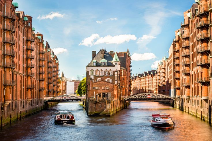 Historische Gebäude am Hafen von Hamburg mit einem Schiff und dem Wasser im Vordergrund.