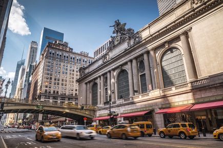 Eine belebte Straße in New York City mit gelben Taxis und Gebäuden.