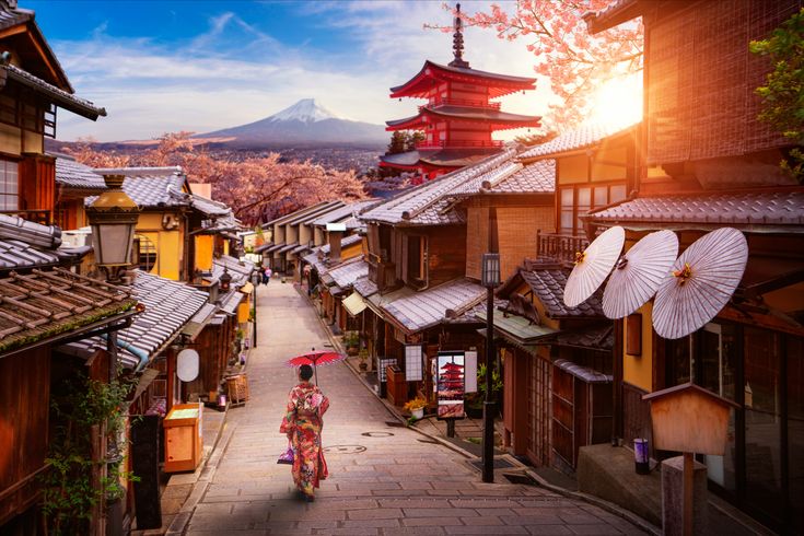 Dorf in Japan, FRau läuft mit Schirm durch die Gasse