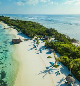 Eine Luftaufnahme eines tropischen Resorts mit Überwasser-Villen und einem langen Steg.