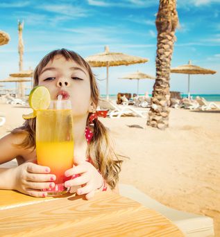 Kind mit Kindercocktail in Ägypten am Strand