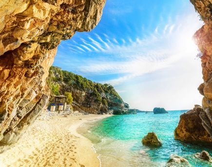 Ein Strand mit türkisfarbenem Wasser und einem felsigen Ufer.