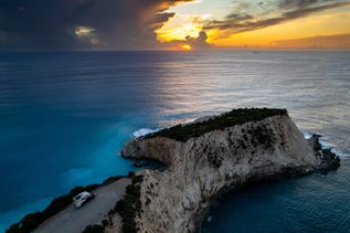 Luftaufnahme eines Sonnenuntergangs über dem Meer auf einem Wohnmobilparkplatz an der Steilküste von Lefkada, Griechenland.
