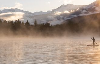 Zwei SUP Paddler auf einem See in Kanada zum Sonnenuntergang