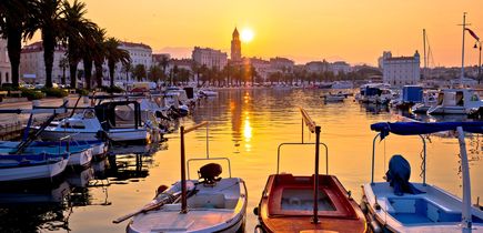 Ein Hafen in Split, Kroatien, mit Booten und Gebäuden bei Sonnenuntergang.