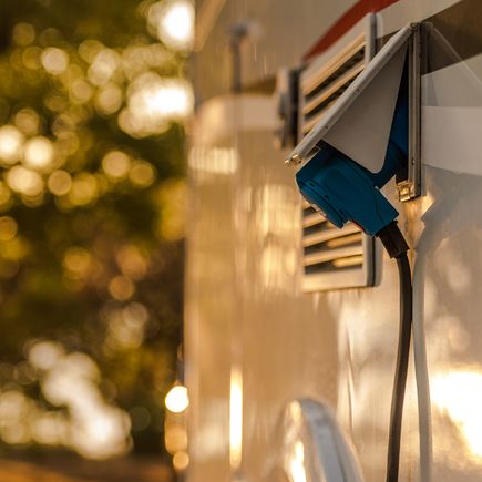 Nahaufnahme eines Ladekabels für ein Elektrofahrzeug, angeschlossen an eine Ladesäule.