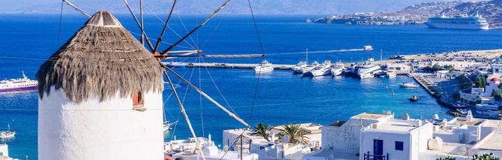 Blick über den Hafen von Mykonos im Vordergrund die berühmten Windmühlen