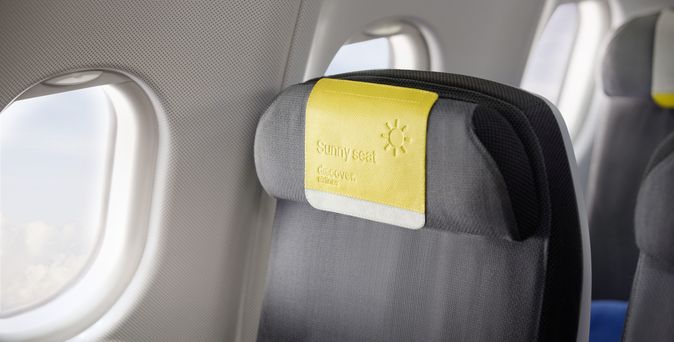 Sitz im Flugzeug mit gelbem Kopfschutz