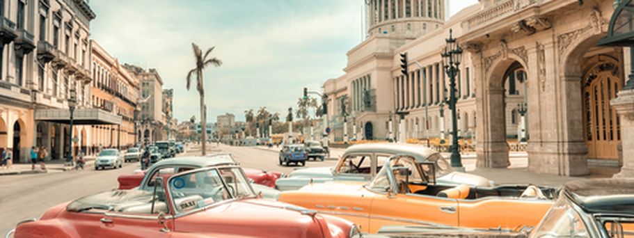 Ein roter Oldtimer fährt auf einer Straße in Havanna.