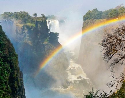 Bunter Regenbogen vor einem Wasserfall in Afrika