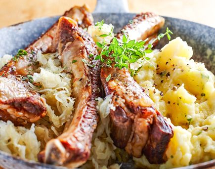 Eine Platte mit Speisen, darunter Fleisch, Kartoffeln und eine Beilage.